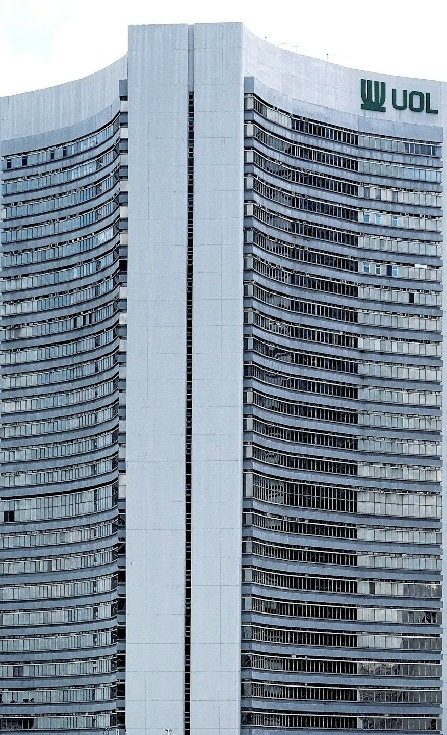 Modern corporate building with grey concrete facade and dark windows.