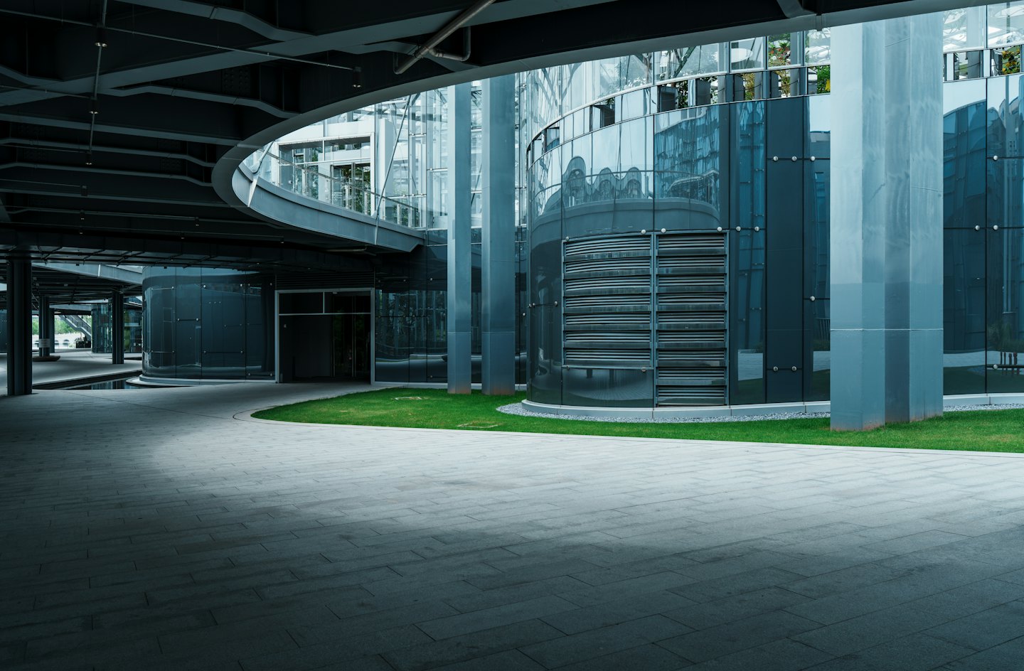 Modern office building with curved glass and dark metal accents.